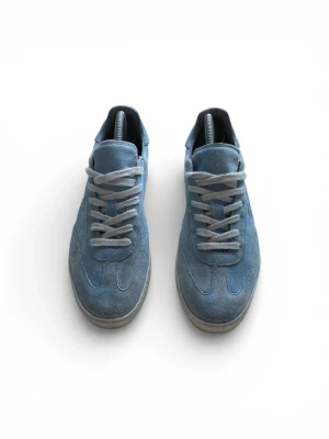 All Saints ljusblå sneakers mocka - Säljer ett par ljusblå sneakers från All Saints i mjuk mocka med vita snören och platt sula. Skorna har en rund tå och diskret guldfärgad logga på sidan. Perfekt för dig som gillar stilrena och fräscha sneakers med snygg retrovibe.