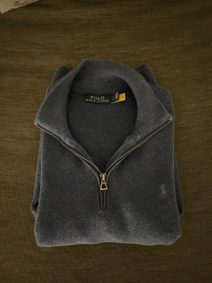 Blå stickad half zip från Polo Ralph Lauren - Snygg blå stickad tröja från Polo Ralph Lauren. Fint skick. Storlek S.