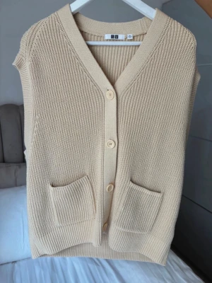 Beige stickad väst från Uniqlo  - Säljer en beige stickad väst från Uniqlo  i storlek XL men passar mer M. Nypris 600