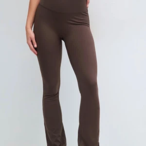 Bruna bootcut tights  - Snygga bruna leggings med bootcut och hög midja. De är stretchiga och sitter tight över låren innan de blir vidare nedtill. Perfekta för dig som gillar en trendig och bekväm look. Materialet är mjukt och följsamt, vilket gör dem riktigt sköna att bära. Som nya!! 