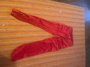 Röda mjukisbyxor från 157, storlek S - Röda mjukisbyxor från 157 i storlek S. Sydd pytte lite tightare.Byxorna har dragsko i midjan och är gjorda i ett mjukt, fleeceliknande material. Perfekta för chill dagar eller när du vill vara extra bekväm. Klassisk passform med fickor och elastisk midja.