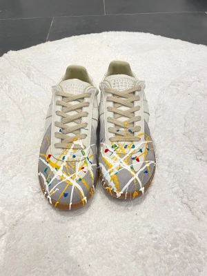 Maison Margiela sneakers  - Unika sneakers från Maison Margiela med vit och grå bas, beige snörning och gummisula.