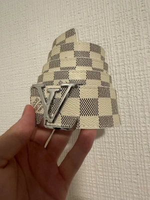 Vitt bälte - Vitt rutigt bälte med silver badge i storlek 100