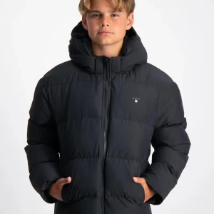 pufferjacka GANT  strl 146-150 ålder 11-12 - Svart pufferjacka från GANT med stilren design och broderad logga på bröstet. Jackan har en rejäl huva, två sidofickor och dragkedja framtill. Perfekt för kalla dagar och har en schysst, lite loose passform som ger en cool vibe.