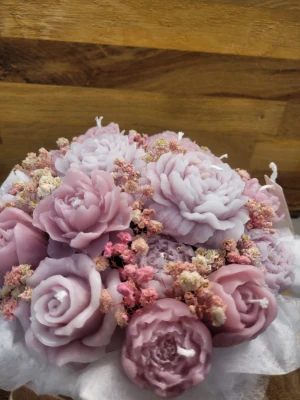 Rosa ljusbukett i box - Unik presentask fylld med handgjutna ljus i form av rosor och pioner i olika nyanser av rosa och lila. Dekorerad med torkade blommor och inslagen i vitt silkespapper, samt en glansig rosett i beige. Perfekt som dekorativt inslag på sminkbordet ellers som en unik present till någon. Kan göras i alla storlekar samt färg och doft.