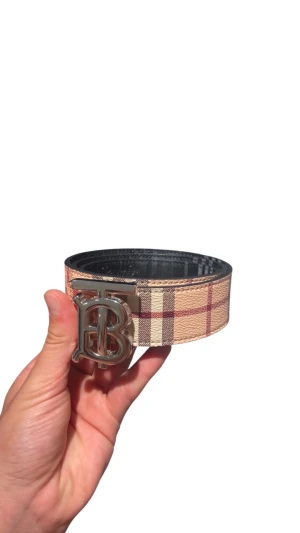 Burberry bälte - Snyggt bälte från Burberry med klassiskt rutigt mönster i beige, rött och svart. Bältet har en bred design😊💯