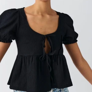 Svart knytblus  - Svart blus från Gina som knyts i fram. Fint skick, inte mycket använd. 