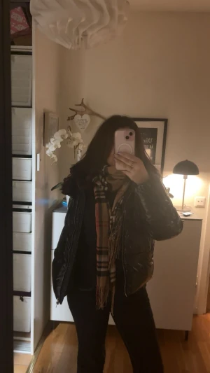 Burberry rutig halsduk i ull - Snygg klassisk halsduk från ” Burberry” med det ikoniska rutiga mönstret i beige, svart, vitt och röda detaljer. Aldrig använd även. Skriv till mig för mer info! 