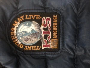 Mörkblå dunjacka från Parajumpers S - Snygg mörkblå dunjacka från Parajumpers i storlek S. Jackan har quiltad design, hög krage och dragkedja framtill. Märkets patch på ärmen och orange detaljer på insidan ger en cool touch. Perfekt för dig som vill ha en lätt och varm jacka med stil.