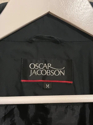 Mörkgrön Oscar Jacobsson vindjacka  - Säljer denna sjukt snygga vindjackan från Oscar Jacobsson⭐️ Färgen är mörkgrön och storleken är M✅ Den har inga defekter och skicket är utomordentligt🙌🤝 Sjukt najs passform och passar perfekt till hösten🍁🙌 Tveka inte på att höra av er dig vid minsta fråga eller fundering😊
