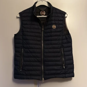 Mörkblå Colmar Väst - Snygg Colmar dunväst, har dock ett litet hål längst ner på baksidan som knappt syns. Storlek 48 och passar S-M Chill stil under höst och vinter. Nypris ca 3000