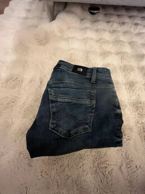 Blå bootcut jeans från LTB - Snygga blå jeans från LTB med klassisk femficksdesign och coola kontrastsömmar på bakfickan. Modellen har låg midja och bootcut-ben som ger en schysst siluett. Jeansen är tillverkade i jeansmaterial med dragkedja och knapp framtill.