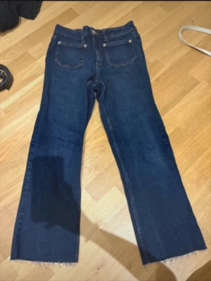 Mörkblå ankellånga jeans - Mörka ankellånga jeans från Zara. Fickor fram och bak. Byxorna slutar byxorna slutar lite under mitten av smalbenet. Har dock sytt in 1-2 cm vid varje lår, märks inte av då de ändå är extremt stretchiga. Bekväma, snygga och extremt billiga.