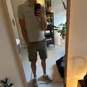 Grå pikétröja från Polo Ralph Lauren - Säljer den här gråa pikétröjan från polo ralph lauren. Passar till mycket och sitter som en smäck! Skriv vid minsta fundering.🙌