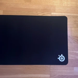 SteelSeries QcK XXL Mousepad - SteelSeries QcK XXL gamingmusmatta i svart, perfekt för både mus och tangentbord. Bra skick, använd en del.