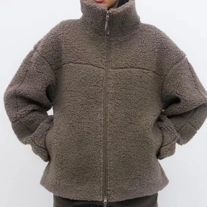 Brun teddyjacka med dragkedja - Mysig brun teddyjacka med hög krage och hel dragkedja framtill. Jackan har en loose passform och är tillverkad i fluffigt fleece-material som håller dig varm under kyliga dagar. Perfekt för dig som gillar en avslappnad och trendig stil. Passar xxs och xs 