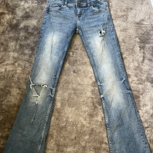 Blå lågmidjade, bootcut jeans med slitning och hål i - Snygga blå lådmidjade jeans från Bershka
