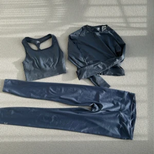 Träningsset - Träningsset med tights, långärmad tight topp och ovadderad sport-bh. Tightsen är använda en del men resten har knappt blivit använda den långärmade är i medium men då det är en kortare modell passar den som en xs/s. Sport-bh:n är en liten annan ton än de andra två men det är knappt märkbart