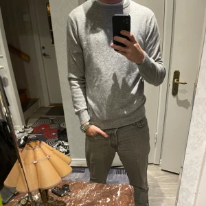 Grå Kashmir tröja från Swedish Fashion - En stilren grå Kashmir tröja från Swedish Fashion. Tröjan har rund halsringning, ribbade muddar och är långärmad. Använd ca 2-3 gånger därför i princip nyskick. En riktigt fet tröja nu inför hösten🍾