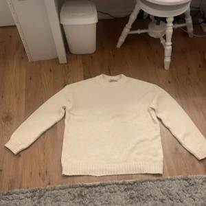 Beige stickad tröja från NA-KD - Säljer en beige stickad tröja från NA-KD i storlek M. Tröjan har rund halsringning, ribbade muddar och är långärmad. Perfekt för lager-på-lager och enkel att matcha med olika outfits. Den är väldigt stir i storlek så funkar nog som L också. Aldrig använt.