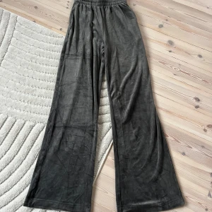 Mörkgrå vida mjukisbyxor från  - Mysiga mörkgrå mjukisbyxor med bred resår i midjan och snörning. Byxorna har en loose och wide passform med raka, vida ben. Mudden har vikt sig (se bild 3) men är lätt att fixa 