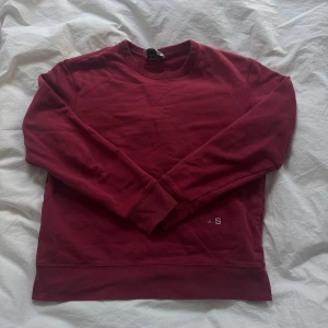 Vinröd sweatshirt från Acne Studios - Vinröd sweatshirt från Acne Studios i 100% bomull. Klassisk rund halsringning, långa ärmar och broderad detalj med 'A S' framtill. Perfekt basic med snygg passform och ribbade muddar vid ärmslut och nederkant.