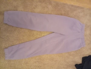 Ljuslila mjukisbyxor från Gina Tricot XS - Ljuslila mjukisbyxor från Gina Tricot, basically basics-kollektionen. Byxorna har resår i midjan och vid bensluten för en skön och avslappnad passform. Perfekta för chill dagar eller när du vill vara bekväm. Tillverkade i mjukt bomullsmaterial.