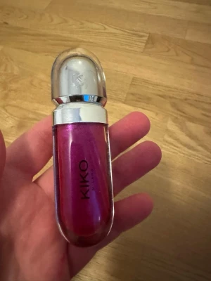 KIKO 3D Hydra Lipgloss nr 23 - Säljer ett KIKO 3D Hydra Lipgloss i färgen 23, en intensivt skimrande rosa nyans med metallic-finish. Kommer i en snygg, rundad tub med silvrigt lock och praktisk applikator. Perfekt för dig som vill ha glansiga och fylliga läppar med extra glow. Endast testad :)