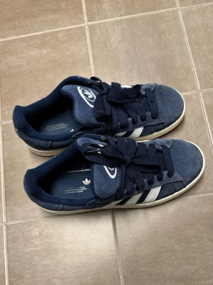 Adidas Campus 00s  - Ett par Adidas campus 00s   använda Max 10 gånger  Obs: På ena skon är snöret lite slitet ( se bild 4 )  Men går ju enkelt att vända på snöret så syns det inte alls. Får även med ett par vita snören som är till skorna