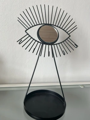 Svart sminkspegel i ögonform - Svart sminkspegel i ögonformad design med rund spegel i mitten. I använt skick.