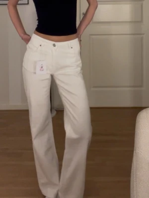 Vita wide leg jeans  - Säljer ett par vita jeans från Never Denim i modellen Mid Wide. Byxorna har midwaist, breda ben och har en stretch, helt nya och orginalspirs är 699kr😊storlek 24/30 jag är 172 för referens.