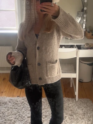 Beige kofta med knappar - Säljer en beige stickad kofta med ribbstickning och stora svarta knappar framtill. Koftan är från Wera och passar perfekt för lite kyligare dagar. Skriv för fler bilder eller frågor så svarar jag inom kort🥰