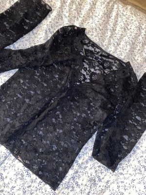 Svart blus  - Black lace blouse from Vero Moda in size S. Elegant and feminine with beautiful lace details and buttons at the front. Perfect for both everyday wear and special occasions – style it with jeans for a casual look or dress it up for evenings. In good condition.