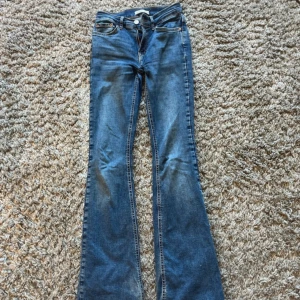 Blåa jeans  - Snygga bootcut jeans, dom är omsydda till low waist men det går att sprätta upp om man inte vill ha de så. En hello Kitty på ena fickan där det har varit ett hål