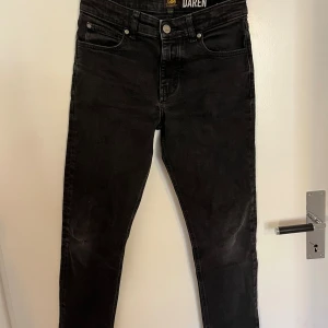 Svarta Lee Daren jeans, 12-13 år - Snygga svarta jeans från Lee, modell Daren. Klassisk femficksdesign med raka ben och normal passform. Jeansen har Lee-logga på knappen och etikett i midjan. Barnstorlek!