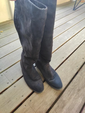 Svarta mockastövlar med dragkedja - Säljer ett par svarta stövlar i mjuk mocka med rund tå och platt sula. Stövlarna har dragkedja längs hela skaftet på baksidan vilket gör dem enkla att ta på. Perfekt till höst och vinter för en stilren look.