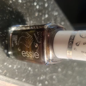 Essie nagellack Wicked Fierce - Nagellack från Essie i färgen Wicked Fierce. Skimrande metallic med brons, guld och gröna toner som skiftar i ljuset. Kommer i klassisk fyrkantig glasflaska med vitt lock. Perfekt för dig som vill ha en unik och cool look på naglarna.