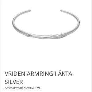 Vriden armbandsring i äkta silver - Snygg och stilren armbandsring i äkta silver med vriden design och små glittrande detaljer framtill. Perfekt för dig som gillar minimalistiska smycken med en twist. Enkel att matcha med andra accessoarer och passar till alla tillfällen.