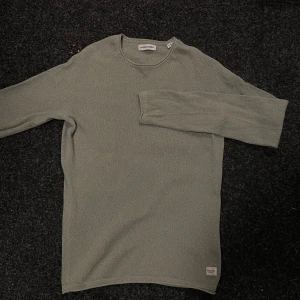 Ljusgrön långärmad tröja Jack & Jones - Säljer en stilren ljusgrön långärmad tröja från Jack & Jones. Tröjan har rund halsringning och är tillverkad i ett mjukt, lätt stickat material. Perfekt för lager-på-lager och enkel att matcha med jeans eller chinos. Köpt för 450kr.