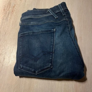 Replay Hyperflex Anbass jeans blå - Snygga Replay Hyperflex Anbass jeans i mörkblå tvätt med klassisk femficksdesign och smal passform. Stretchigt material för extra komfort och rörelsefrihet. Perfekt för dig som vill ha stilrena jeans med modern känsla.