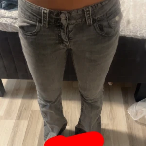 Grå bootcut jeans från Gina Tricot - Snygga grå jeans från Gina Tricot i storlek 164. Modellen har bootcut-ben och klassisk femficksdesign. Jeansen har en cool tvättad look och är tillverkade i ett mjukt jeanstyg som sitter skönt på kroppen.