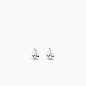 Silverörhängen med droppformad sten - Snygga örhängen i silver med droppformad klar sten som ger en glittrig och elegant look. Stiftmodell som sitter nära örat och passar perfekt för att addera lite extra shine till din stil. Kommer i en brun ask. Enbart testad. Nypris 650