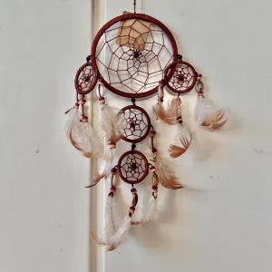 Drömfångare  - Lappen finns kvar och har aldrig använts, men det finns defekter som orsakades när den tillverkades (lim och långa trådar på vissa ställen).  Fjädrarna är äkta. Utan öglan är den 30 cm lång. Öglan är 14 cm. Total längd är 44cm.🍁