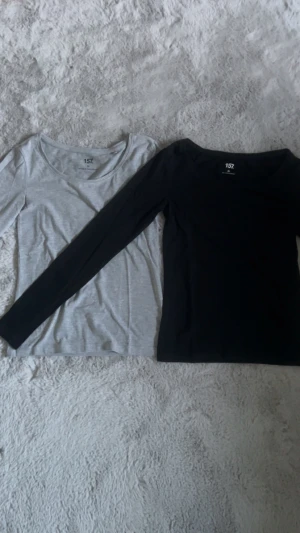 2 långärmade tröjor från Lager 157, svart & grå  - Två basic långärmade tröjor från Lager 157, en i svart och en i ljusgrå. Båda har rund halsringning sitter väldigt bra och är i mjuk bomull, perfekta att styla med jeans eller kjol. Snygga och enkla plagg för din garderob.