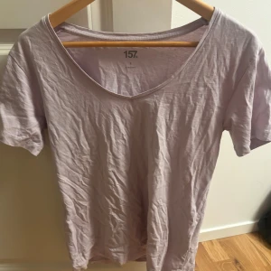 Ljuslila t-shirt från 157, v-ringad - En basic ljuslila t-shirt från 157 i 100% bomull. T-shirten har v-ringad hals och korta ärmar, perfekt för en chill och enkel stil. Skön passform och mjukt material som funkar till det mesta.