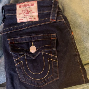 True Religion Becca Bootcut Jeans - Säljer ett par mörkblå True Religion Becca jeans i bootcut-modell med midwaist. Aldrig använt. Skriv gärna för fler bilder!!!
