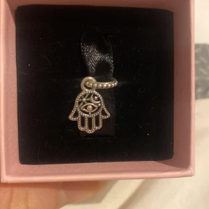 Pandora charm hamsa hand  - hängberlock från Pandora i form av en Hamsa-hand med öga, tillverkad i sterlingsilver. Den är i nyskick och skickar med lådan. Ny pris 350 säljer för 250 går att förhandla:)