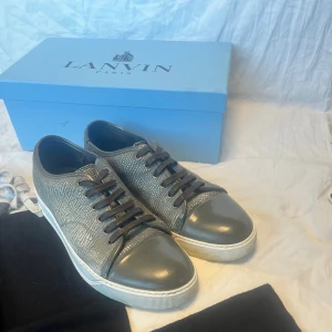 Lanvin sneakers storlek 43 - Ett par fina lanvins De är i storlek 43 och passar bra, skick är 7/10 lite små skador som syns. kommer med lådan, dustbag. Skriv om du har någon fundering✅👌 