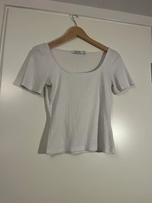 Vit ribbad T-shirt  - Vit ribbad T-shirt med tight passform, köpt secondhand och använd av mig fåtal gånger, inga tecken på användning utom att den är lite nopprig💞