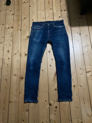 Levi's 510 skinny jeans blå W32 L34 - Säljer ett par Levi's 510 skinny jeans i mörkblå tvätt. Klassisk femficksmodell med snygga slitningar och smal passform. Jeansen har dragkedja och knappstängning, samt Levi's patch bak i midjan. Perfekt för dig som gillar en modern och tajt look.